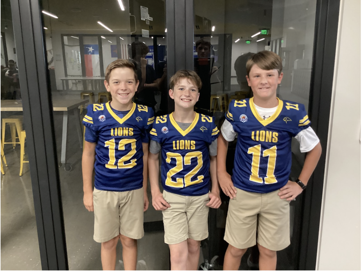 Sixth Grade students Logan Abrams, Kross Wrona, and Tyler Hibbetts wear their Lions jerseys to school before gameday. 